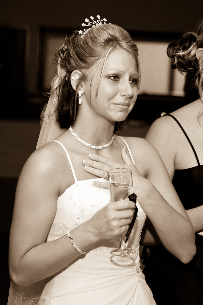 Candid sepia photograph of a bride during toast
