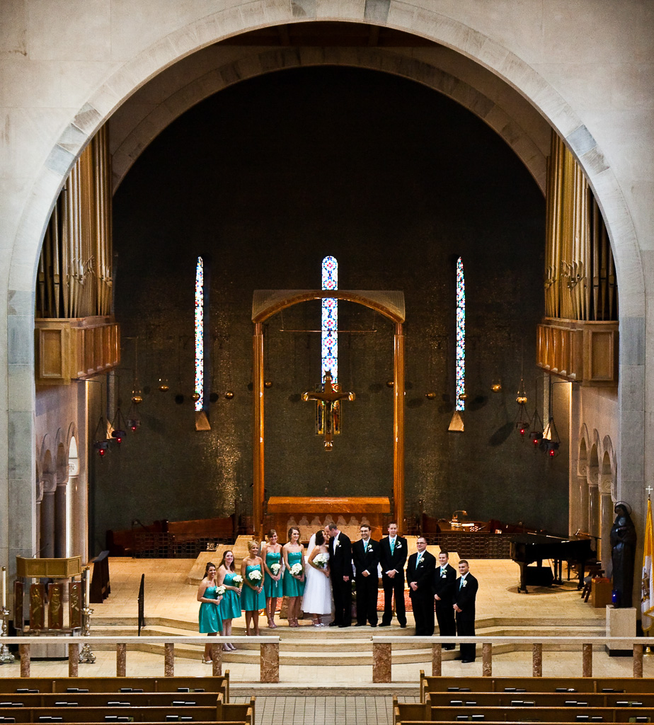 Formal photograph of bride and groom with wedding party in church